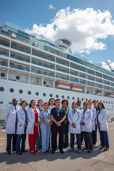 A group of Maritime Physicians and Nurses on the dock with a cruise ship in the background.